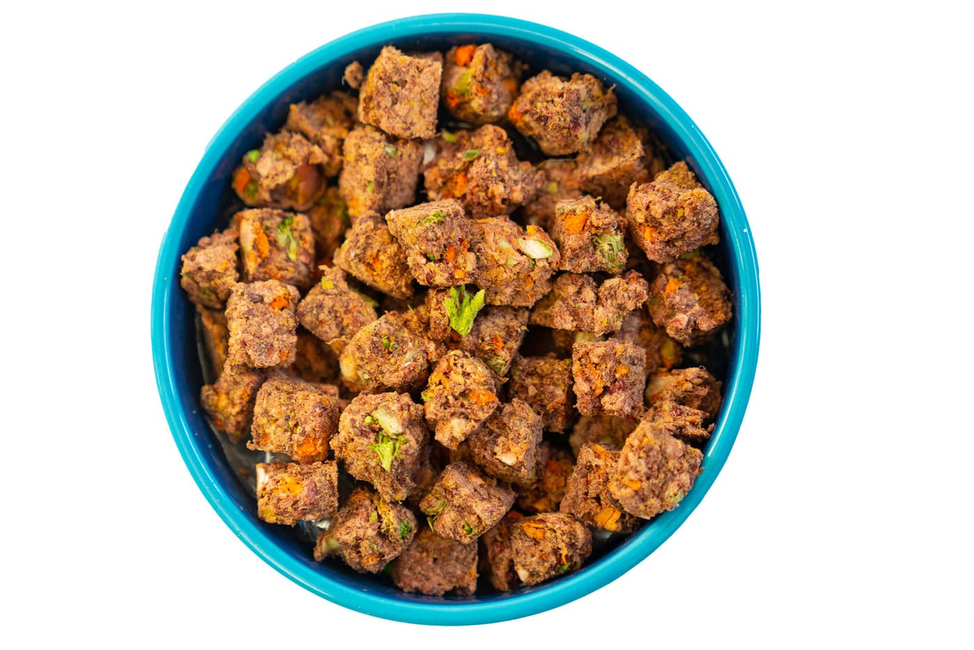Top-down view of a teal bowl filled with AlphaPak freeze-dried raw cubes, carrot and broccoli visible
